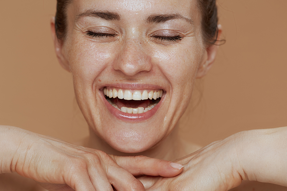 smiling woman with wet face washing